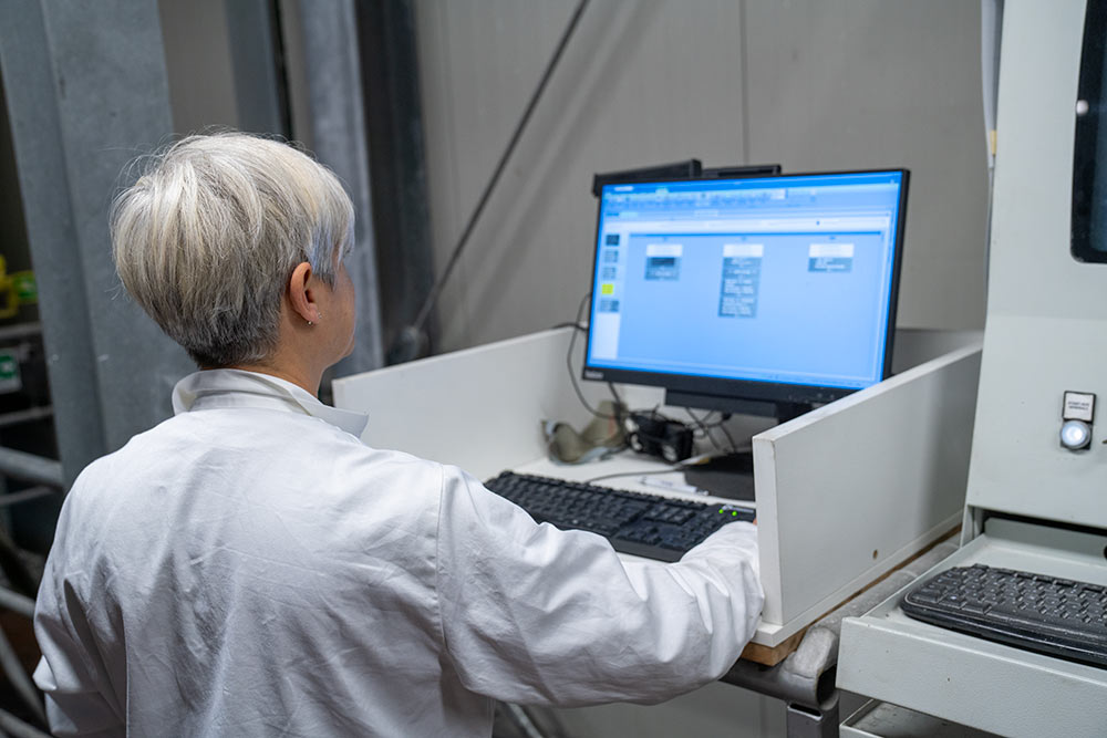 la responsabile tecnica di Glueton controlla a computer il processo di produzione della colla industriale personalizzata