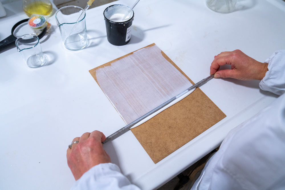 Il tecnico di laboratorio Glueton fa una prova di tenuta della colla personalizzata su un substrato di mdf